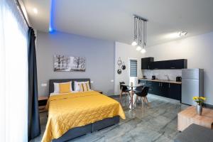 a bedroom with a yellow bed and a kitchen at Ntg Studios in Katerini