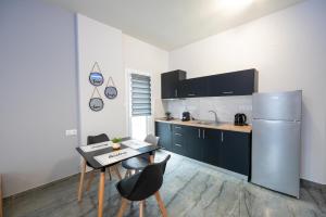a kitchen with a refrigerator and a table and chairs at Ntg Studios in Katerini