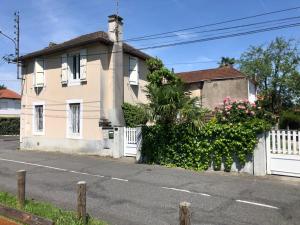 dom z białym płotem przed nim w obiekcie Petite maison avec terrasse w mieście Jurançon