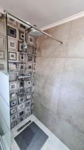 a shower with a glass door and a ladder in a bathroom at Anna Garden Sidari in Sidari