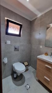 a bathroom with a toilet and a sink and a window at Anna Garden Sidari in Sidari
