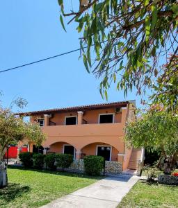 a large orange house with trees in front of it at Anna Garden Sidari in Sidari