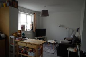 uma sala de estar com uma mesa e um sofá em Bright & Chilled DB room with own bathroom! em Londres