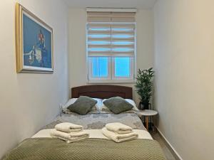 a bedroom with a bed with towels on it at Apartments Center Opatija Ziric in Opatija