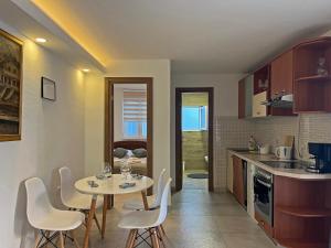 a kitchen with a table and white chairs in a room at Apartments Center Opatija Ziric in Opatija