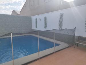 una piscina con un cartel en el lateral de un edificio en LA MANCHEGUITA DE MADRIGUERAS 5 DORMITORIOS DOBLES CHALET CON PISCINA Y BARBACOA ideal familias 11 personas, 