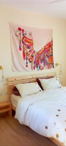 Schlafzimmer mit einem Bett mit Wandgemälde in der Unterkunft מדברא - צימר בירוחם in Jerocham