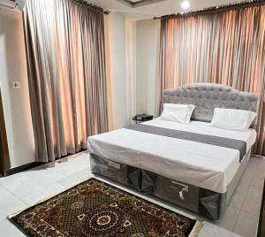 a bedroom with a large bed in front of a window at Northern Suites Bahria town in Rawalpindi