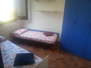 a small room with a bed and a blue door at Villino Dapè in Campofelice di Roccella