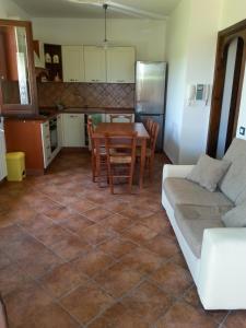 een keuken en een woonkamer met een tafel en een bank bij Villino Dapè in Campofelice di Roccella