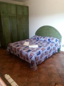 a bedroom with a bed with a bedspread on it at Villino Dapè in Campofelice di Roccella