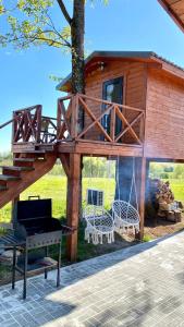 a tree house with a swing and a grill at Lake House in Anykščiai