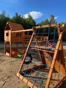 a wooden play structure with a play house on it at Osada Gardenia in Ślesin
