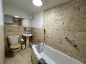 ein Badezimmer mit einer Badewanne, einem WC und einem Waschbecken in der Unterkunft Wookey Hole Hideaway in Wookey Hole
