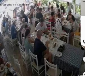 a group of people sitting at tables in a restaurant at Anxhelos Hotel in Himare