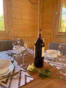 a bottle of wine sitting on top of a wooden table at Osada Gardenia in Ślesin +25 photos