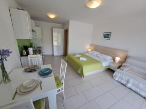 a small room with a bed and a kitchen at Apartments Fran in Baška