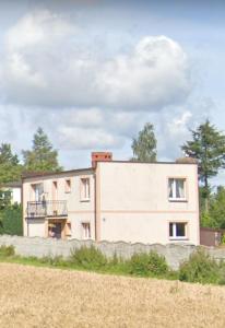 une maison sur le côté d'un champ dans l'établissement Apartament Pod Bocianami, à Żelistrzewo