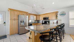 a kitchen with wooden cabinets and a island with bar stools at 414 E 17th Ave, 2nd Floor in North Wildwood