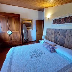 um quarto com uma cama grande e uma cabeceira em madeira em Agriturismo Tenuta La Fratta em Bagni di Lucca