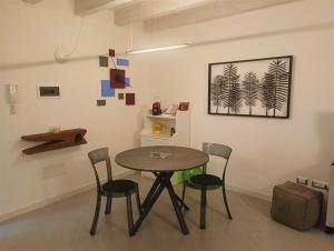a dining room with a table and four chairs at CIVICO22 in Comacchio