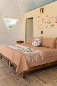 a bed in a room with butterflies on the wall at Luz de Luna Glamping in Pueblo Nuevo