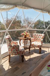 two chairs and a table on a balcony at Luz de Luna Glamping in Pueblo Nuevo