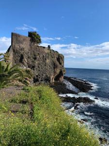 a castle on a cliff next to the ocean at Casaagnese in Catania