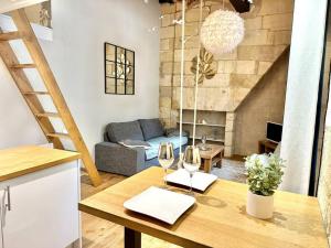 Place de la Bourse Bordeaux hyper-centre في بوردو: غرفة معيشة مع طاولة مع كأسين من النبيذ