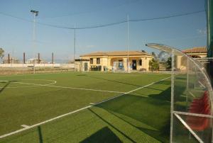 een voetbalveld met een voetbalveld voor een gebouw bij Villino Dapè in Campofelice di Roccella