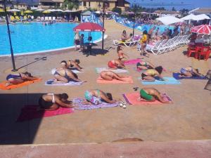 een groep mensen die yoga doen op het strand bij Villino Dapè in Campofelice di Roccella