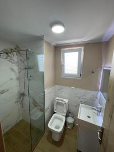 een badkamer met toilet, douche en wastafel bij Resol Hotel in Ksamil +10 foto's