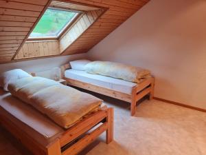 a attic bedroom with two beds and a window at Dachwohnung in Welschenrohr in Welschenrohr