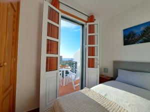 una camera con letto e vista su un balcone di Ferienhaus mit Meerblick Playa Abades ad Abades