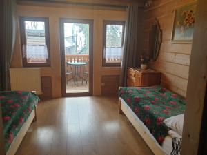 1 Schlafzimmer mit 2 Betten und einem Tisch auf dem Balkon in der Unterkunft STYLOWE APARTAMENTY W PORONINIE in Poronin