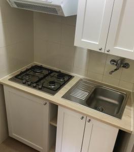 uma cozinha com um fogão e um lavatório em La Corbula - Casa Vacanze - Q5992 em Fluminimaggiore