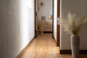 a hallway with a vase of feathers in a room at Porthcurno Barns, The Big Barn - Spacious & cosy cottage, walk to Porthcurno beach, Pedn Vouder & Minack Theatre in Penzance