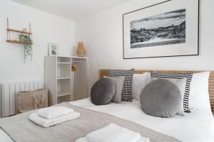 a bedroom with a bed with pillows on it at Porthcurno Barns, The Big Barn - Spacious & cosy cottage, walk to Porthcurno beach, Pedn Vouder & Minack Theatre in Penzance