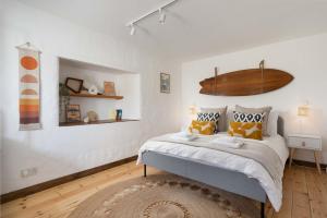 um quarto com uma cama grande e almofadas amarelas em Spacious & cosy cottage, walk to Porthcurno beach, Pedn Vouder, Minack & PK Museum em Penzance