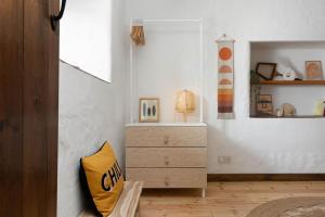 a bedroom with a dresser and a yellow pillow at Porthcurno Barns, The Big Barn - Spacious & cosy cottage, walk to Porthcurno beach, Pedn Vouder & Minack Theatre in Penzance