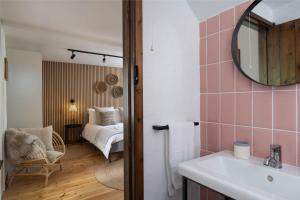 a bathroom with a sink and a bedroom with a bed at Porthcurno Barns, The Big Barn - Spacious & cosy cottage, walk to Porthcurno beach, Pedn Vouder & Minack Theatre in Penzance