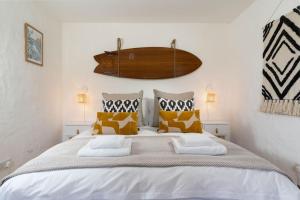 a bedroom with a large bed with yellow and white pillows at Porthcurno Barns, The Big Barn - Spacious & cosy cottage, walk to Porthcurno beach, Pedn Vouder & Minack Theatre in Penzance