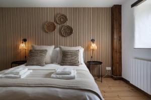 a bedroom with a large white bed with striped walls at Porthcurno Barns, The Big Barn - Spacious & cosy cottage, walk to Porthcurno beach, Pedn Vouder & Minack Theatre in Penzance