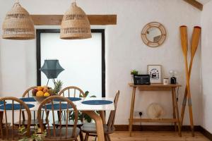 a dining room with a table and chairs at Porthcurno Barns, The Big Barn - Spacious & cosy cottage, walk to Porthcurno beach, Pedn Vouder & Minack Theatre in Penzance