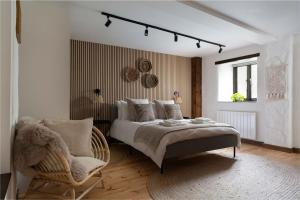 a bedroom with a large bed and a chair at Porthcurno Barns, The Big Barn - Spacious & cosy cottage, walk to Porthcurno beach, Pedn Vouder & Minack Theatre in Penzance