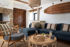 a living room with a blue couch and a table at Porthcurno Barns, The Big Barn - Spacious & cosy cottage, walk to Porthcurno beach, Pedn Vouder & Minack Theatre in Penzance