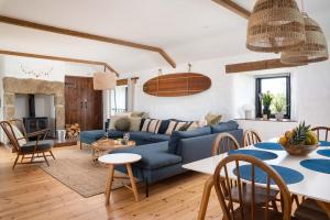 a living room with a blue couch and a table at Porthcurno Barns, The Big Barn - Spacious & cosy cottage, walk to Porthcurno beach, Pedn Vouder & Minack Theatre in Penzance