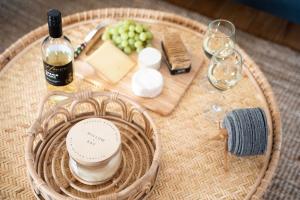 a table with a basket of wine and cheese and wine glasses at Porthcurno Barns, The Big Barn - Spacious & cosy cottage, walk to Porthcurno beach, Pedn Vouder & Minack Theatre in Penzance