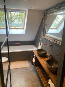 een badkamer met 2 wastafels en 2 ramen bij Hoeve Vierhuyse in Akersloot