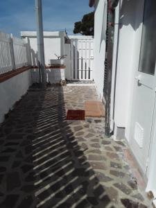 a walkway leading to a white building with a fence at Villetta a schiera nei pressi del mare in Livorno